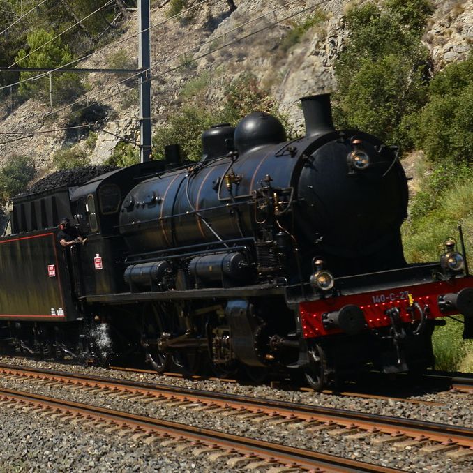 La 140 C 27 en pleine voie, panache de vapeur, dans une tranchée rocheuse